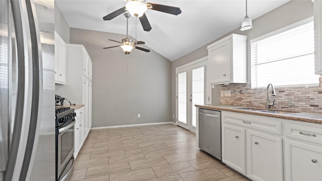 kitchen with plenty of natural light, appliances with stainless steel finishes, sink, and white cabinets