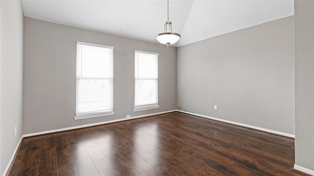 spare room with vaulted ceiling and dark hardwood / wood-style floors