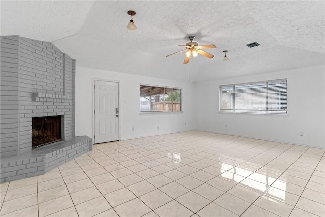 unfurnished living room featuring ceiling fan, vaulted ceiling, a brick fireplace, and light tile patterned floors