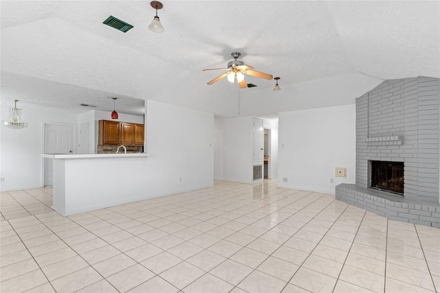 unfurnished living room featuring vaulted ceiling, a fireplace, light tile patterned floors, ceiling fan, and a textured ceiling