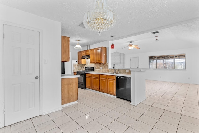 kitchen with hanging light fixtures, sink, light tile patterned floors, and black appliances