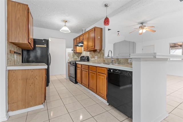 kitchen featuring light tile patterned flooring, sink, tasteful backsplash, pendant lighting, and black appliances