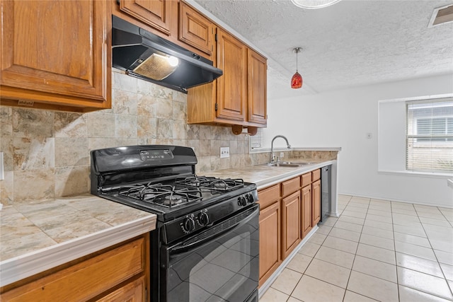 kitchen with light tile patterned flooring, black range with gas stovetop, sink, and decorative backsplash