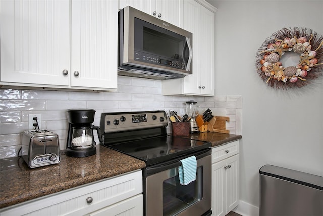 kitchen with white cabinetry, appliances with stainless steel finishes, tasteful backsplash, and dark stone counters