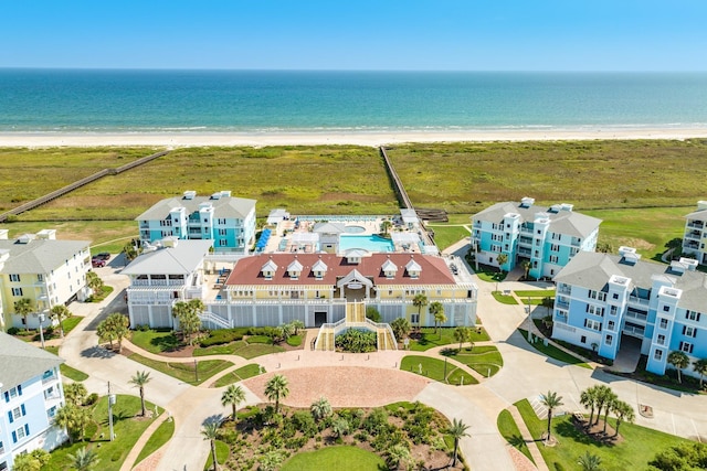 birds eye view of property with a water view and a beach view