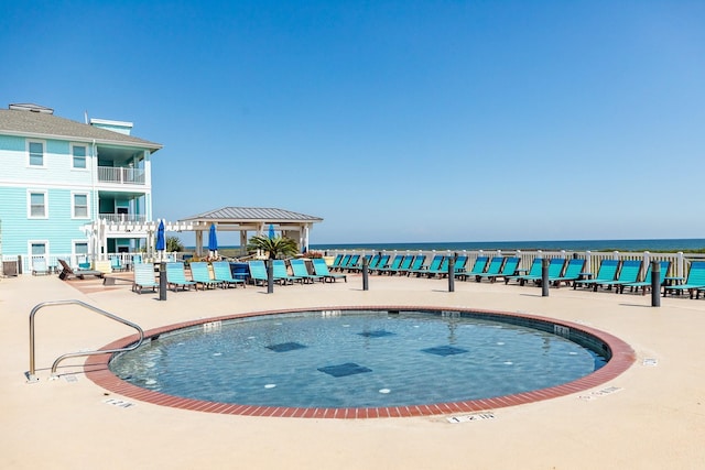 view of swimming pool with a gazebo and a water view