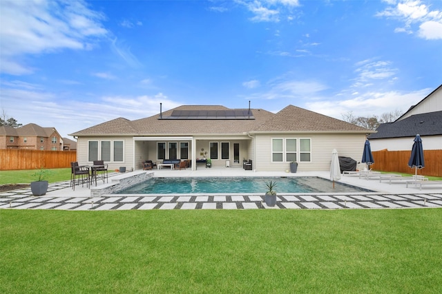 back of house featuring a patio, solar panels, a fenced in pool, and a yard