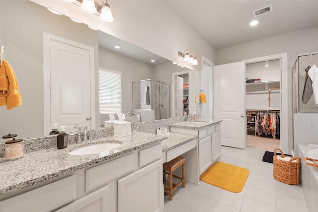 bathroom featuring vanity, a shower with door, and tile patterned floors