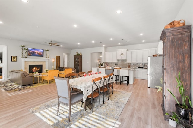 dining space with ceiling fan and light hardwood / wood-style floors