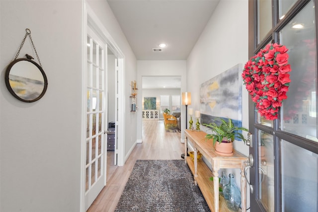 corridor featuring light wood-type flooring and french doors