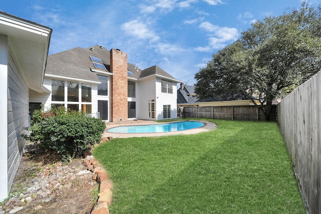 view of swimming pool with a yard