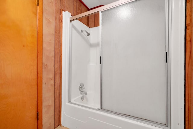 bathroom with bath / shower combo with glass door