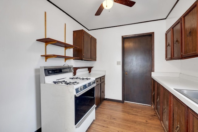 kitchen featuring ceiling fan, sink, white range with gas cooktop, and light hardwood / wood-style floors