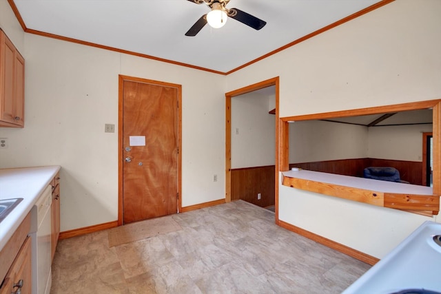 kitchen with white dishwasher, ornamental molding, ceiling fan, and wood walls