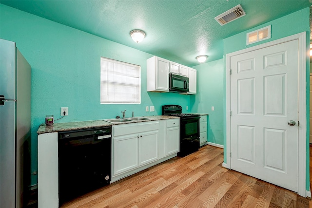 kitchen featuring sink, light stone counters, black appliances, light hardwood / wood-style floors, and white cabinets