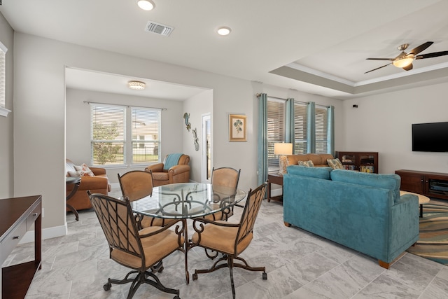 dining room with a raised ceiling and ceiling fan