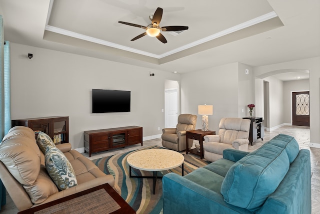 living room featuring crown molding, ceiling fan, and a tray ceiling