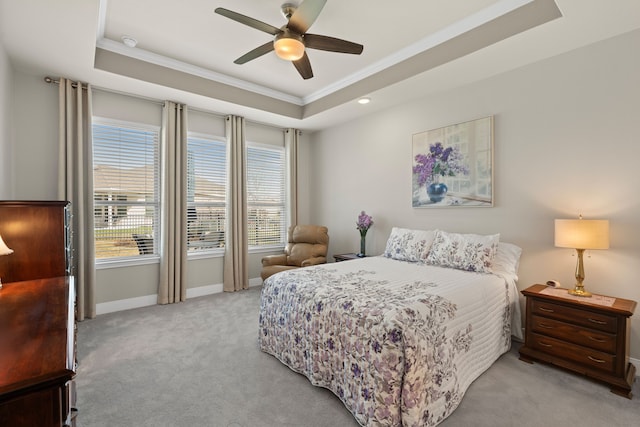 carpeted bedroom featuring a raised ceiling, crown molding, and ceiling fan