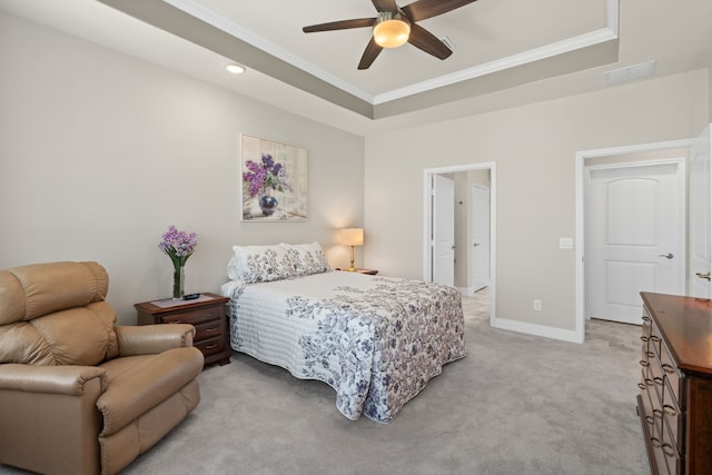 carpeted bedroom with ornamental molding, ceiling fan, and a tray ceiling