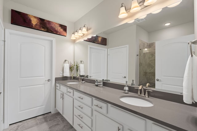 bathroom with tiled shower and vanity