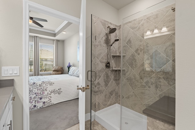 bathroom featuring ornamental molding, vanity, an enclosed shower, ceiling fan, and a raised ceiling