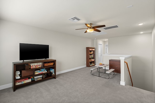 sitting room with ceiling fan and light colored carpet