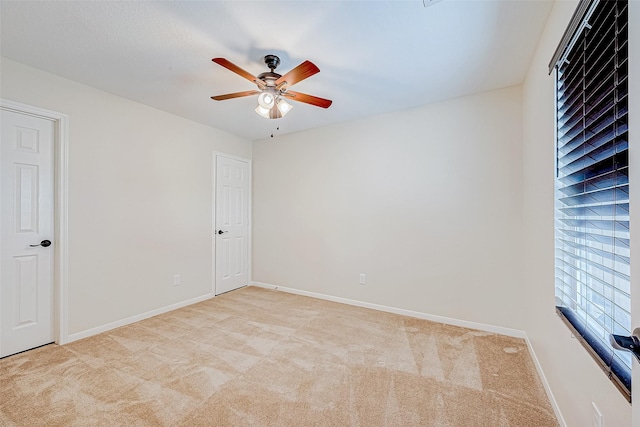 carpeted spare room with ceiling fan