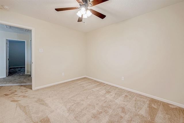 empty room with light carpet, a textured ceiling, and ceiling fan