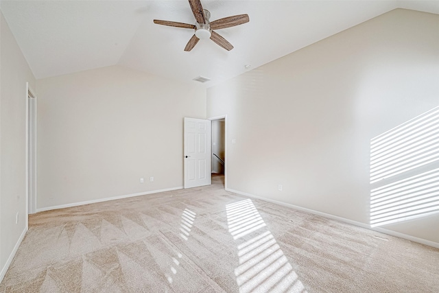 spare room with lofted ceiling, light carpet, and ceiling fan