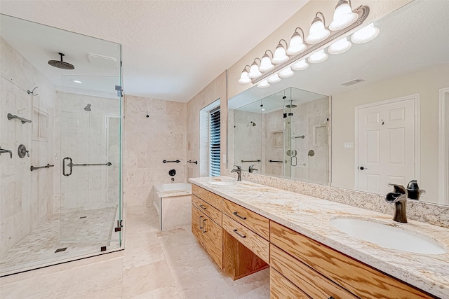 bathroom featuring vanity, a shower with shower door, and a textured ceiling