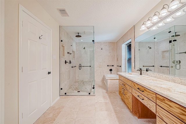 bathroom with vanity, a textured ceiling, and a shower with shower door