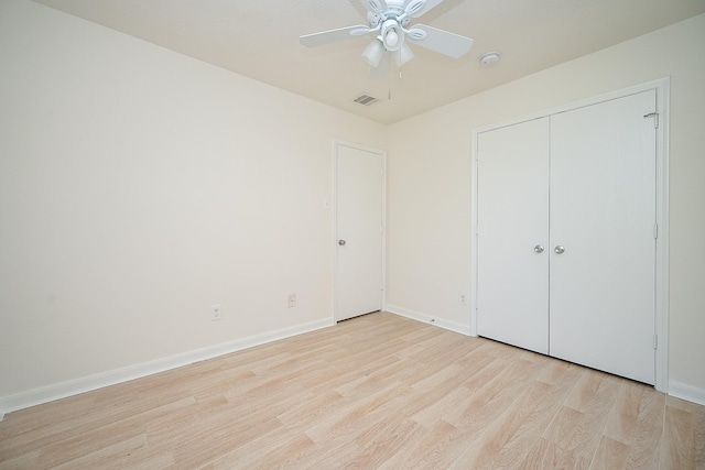 unfurnished bedroom with ceiling fan, a closet, and light wood-type flooring