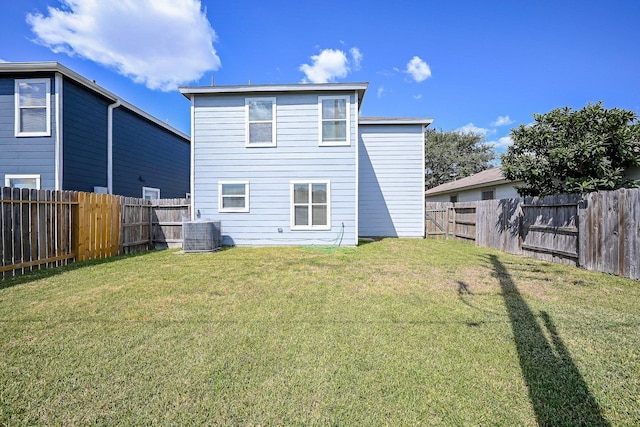 rear view of property featuring cooling unit and a yard