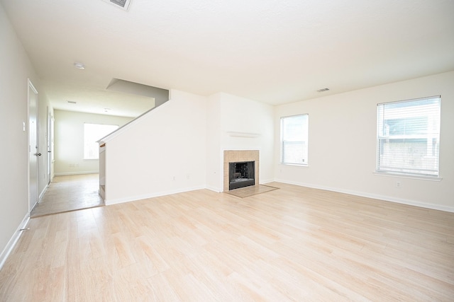 unfurnished living room with a fireplace and light hardwood / wood-style floors