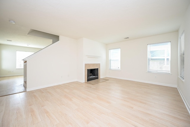 unfurnished living room featuring a fireplace and light hardwood / wood-style flooring