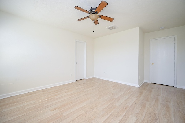 empty room with ceiling fan and light hardwood / wood-style floors