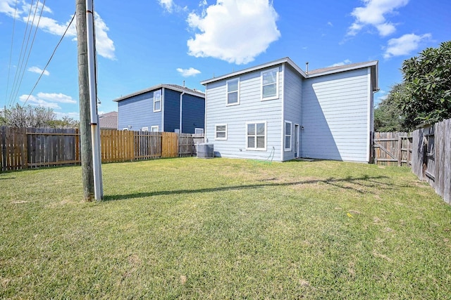 back of property featuring cooling unit and a yard