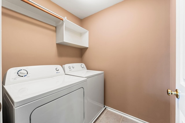 laundry room featuring washing machine and dryer and light tile patterned floors