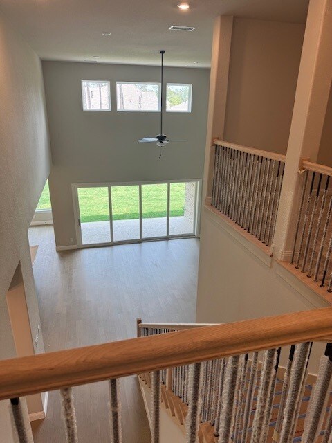 16147 Rustling Woods Rd, Conroe, TX 77302 - stairs with plenty of natural light, a towering ceiling, ceiling fan, and wood finished floors