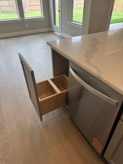 16147 Rustling Woods Rd, Conroe, TX 77302 - kitchen with dishwasher, light wood-style flooring, and plenty of natural light