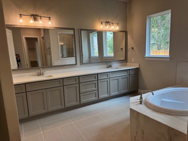 16147 Rustling Woods Rd, Conroe, TX 77302 - full bathroom featuring double vanity, a garden tub, and tile patterned floors
