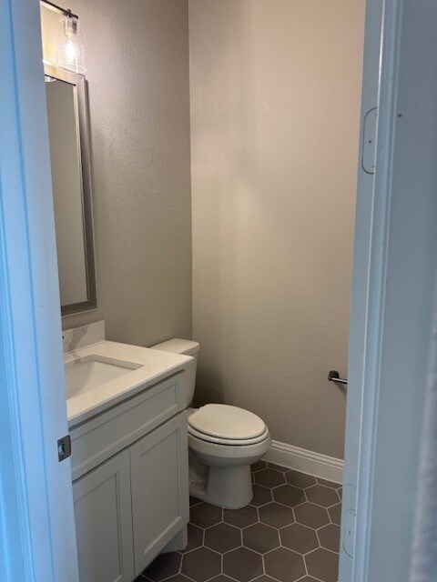 16147 Rustling Woods Rd, Conroe, TX 77302 - bathroom featuring vanity, toilet, and tile patterned floors