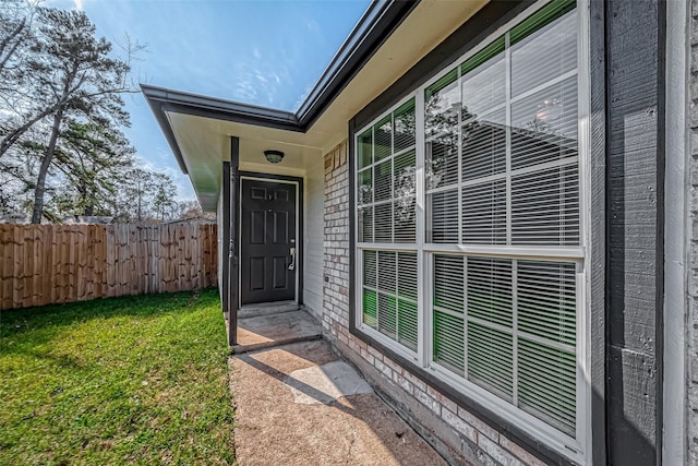 view of exterior entry featuring a yard