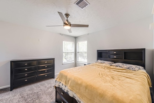 bedroom with a textured ceiling, light colored carpet, and ceiling fan