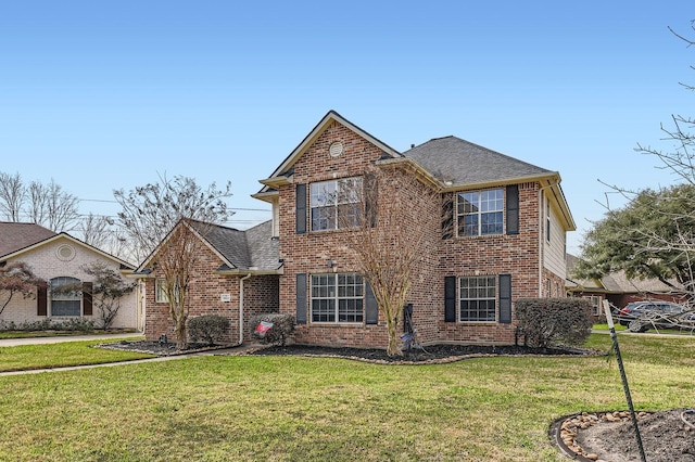 traditional-style home featuring brick siding, roof with shingles, and a front yard