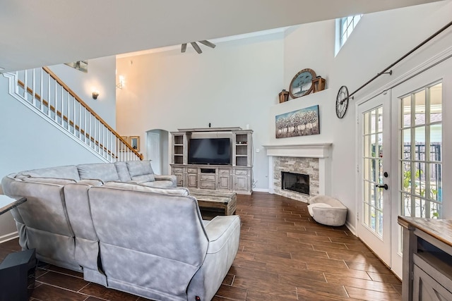 living room featuring a high ceiling, french doors, and a fireplace