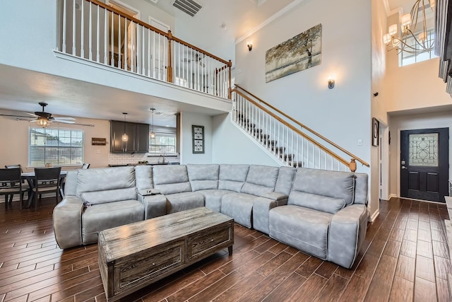 living room featuring ceiling fan with notable chandelier