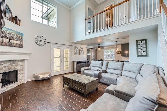 living room with ceiling fan, dark wood-type flooring, a fireplace, french doors, and ornamental molding