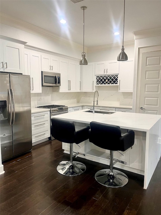 kitchen with white cabinetry, appliances with stainless steel finishes, sink, and hanging light fixtures