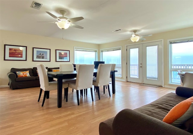 dining space with ceiling fan, light wood-type flooring, and french doors